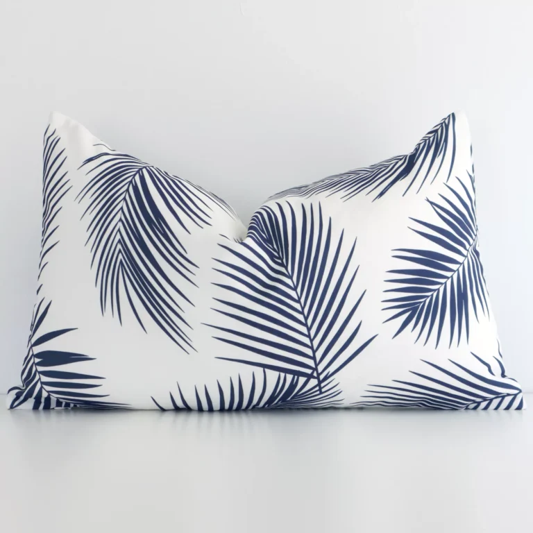 Navy palm cushion positioned in front of a brick wall. It has rectangle dimensions and is made from an outdoor material.