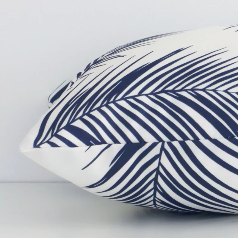 Enlarged image of the side of this navy outdoor cushion. The angle highlights how the rectangle design and palm decorative finish are joined along the seam.