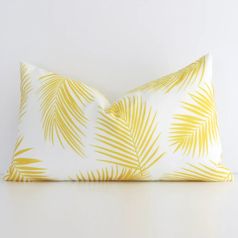 otama-palm-waterproof-rectangular-yellow-outdoor-cushion-cover---rectangle---sc728-30 Yellow palm printed cushion leans elegantly against a white wall. It has been crafted from a high quality outdoor material and has a rectangle shape.