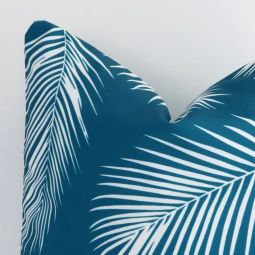 Enlarged shot of a square teal cushion cover that highlights that palm motif on its outdoor fabric.