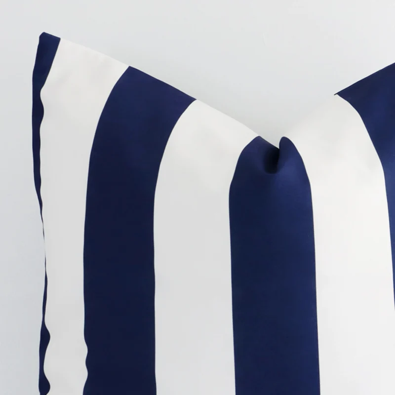 Cropped shot of top left corner of this outdoor navy striped cushion cover. This viewpoint shows the outdoor fabric and large shape with more precision.
