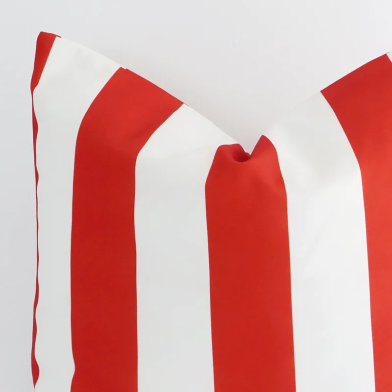 A macro image of the top left corner of this outdoor cushion. It is possible to see the finer detail of the large size and red stripe colour.