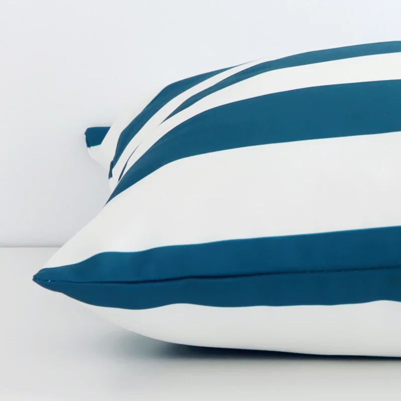 A side view of teal striped cushion that has outdoor fabric and a large size.