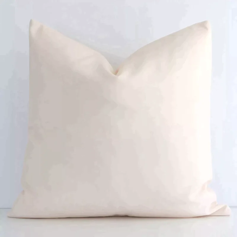 otama-waterproof-beige-outdoor-cushion-cover---sc689-45 Solid-coloured square beige cushion positioned in front of a white wall. It is made of outdoor fabric.