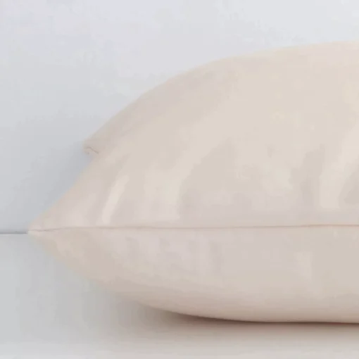 Side angle shot of outdoor square cushion cover. The beige hue and solid colour stye are shown along its seams.