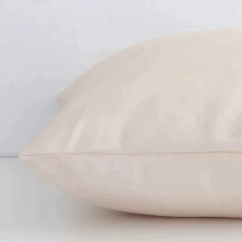 Side angle shot of outdoor square cushion cover. The beige hue and solid colour stye are shown along its seams.