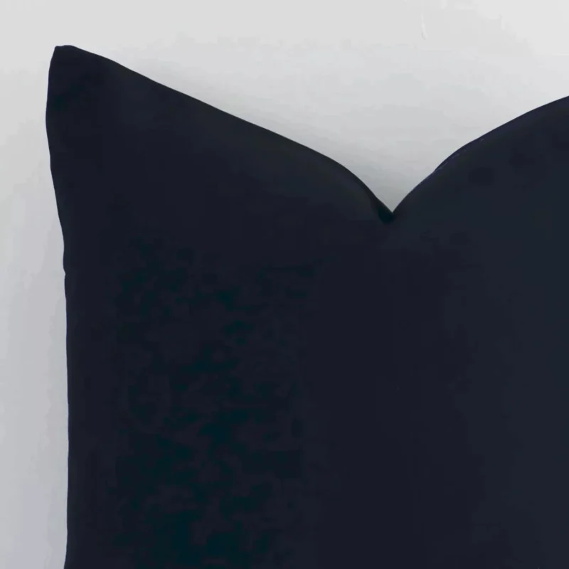 Focused view of solid colour designed square cushion cover. The shot shows details of its outdoor material and black colour.