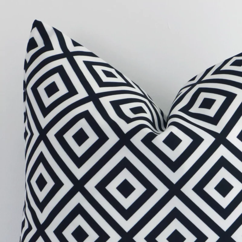Focused view of geometric square cushion cover. The shot shows details of its outdoor material and black-and-white colour.