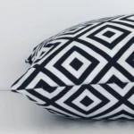 Lateral view of front and back panels of this geometric outdoor cushion cover in a square size and with black-and-white colouring.