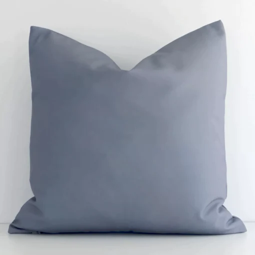 Grey solid-coloured cushion cover sits against a white wall. It is constructed from a superior looking outdoor material and has square shape.