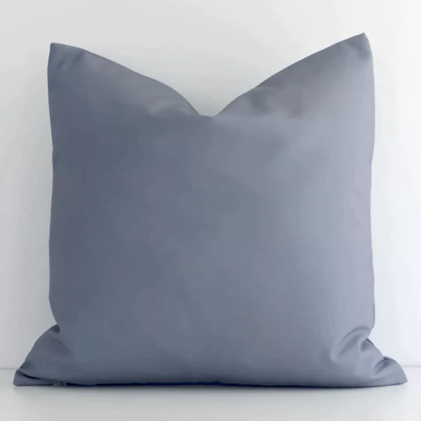 Grey solid-coloured cushion cover sits against a white wall. It is constructed from a superior looking outdoor material and has square shape.