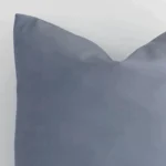 Macro shot showing the top left side of this square outdoor cushion. The grey hue and solid colour design are magnified.