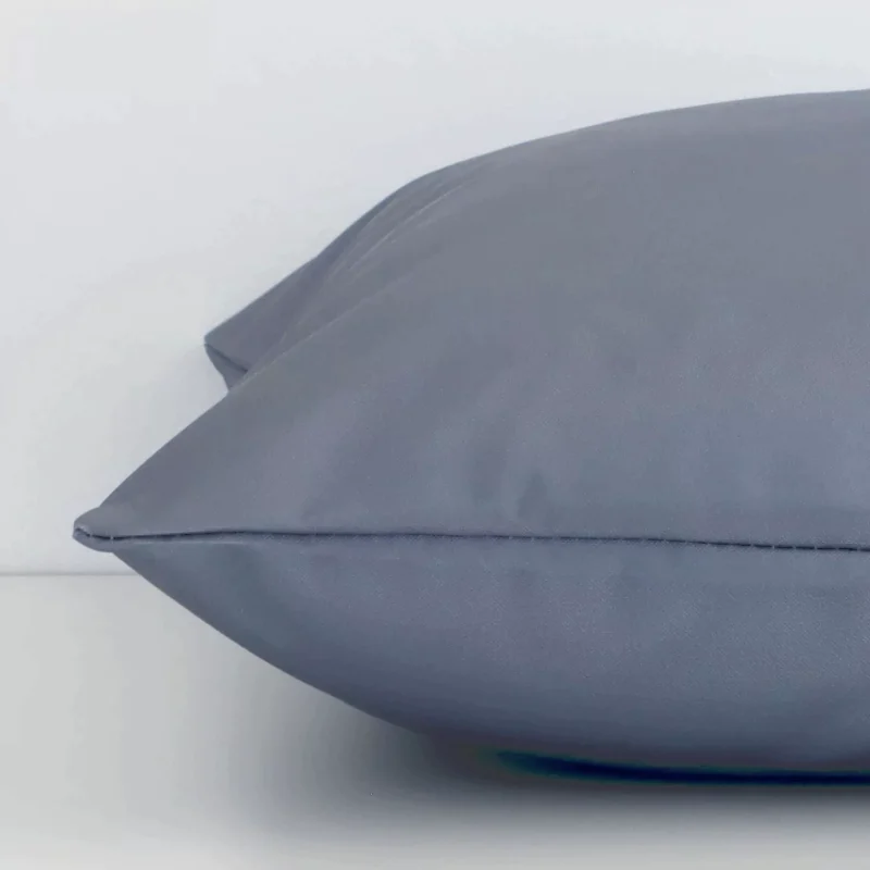Lateral viewpoint of this outdoor square cushion. The solid grey colour design is shown from the side showing the front and rear panels.