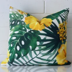 A graceful square yellow cushion with a floral style on durable outdoor fabric.