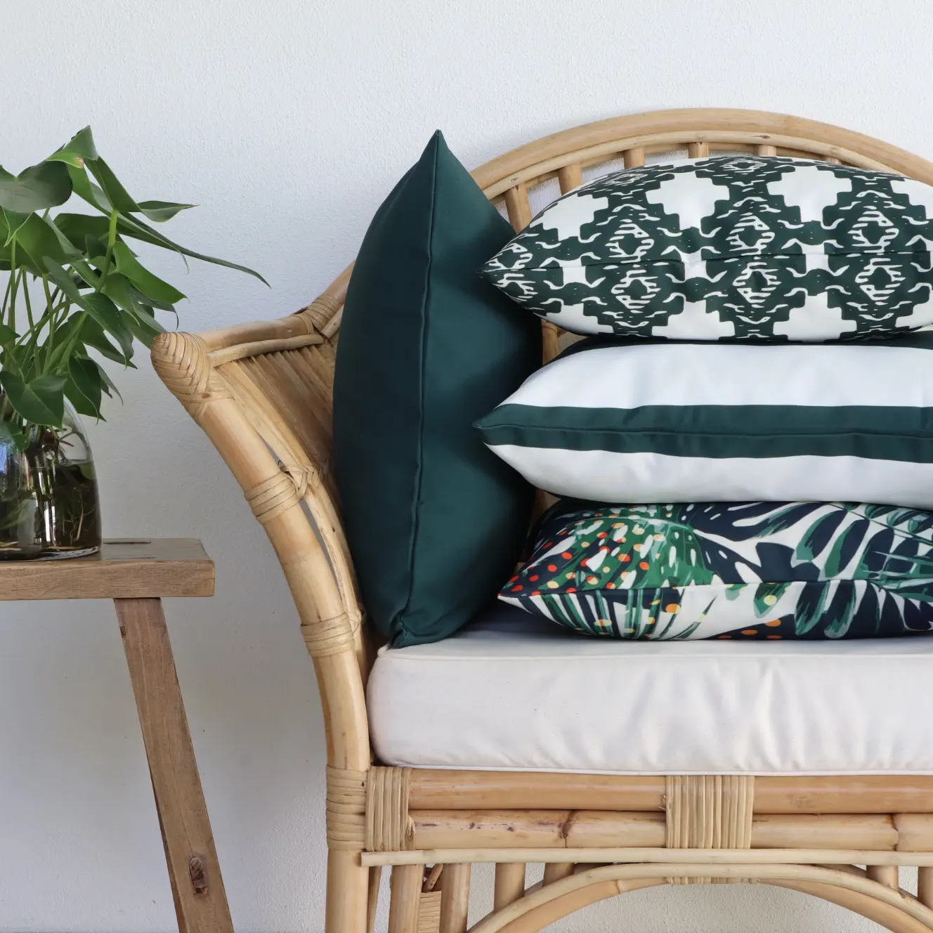 An outdoor seat with outdoor cushions arranged on it in matching colours.