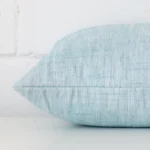 Side shot showing the seam of this rectangle duck egg cushion that is made from a linen material.