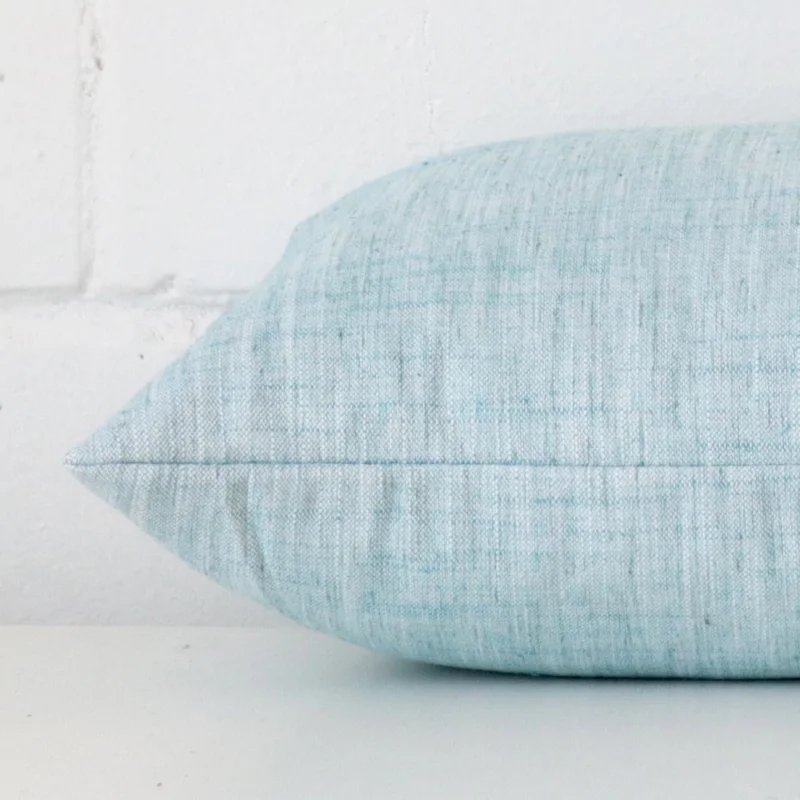 Side shot showing the seam of this rectangle duck egg cushion that is made from a linen material.
