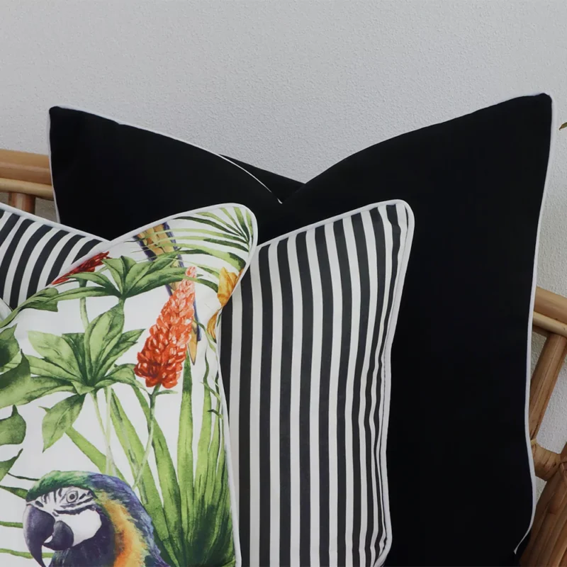 Close-range image of 3 black outdoor cushions. The colour and material can be seen in detail.