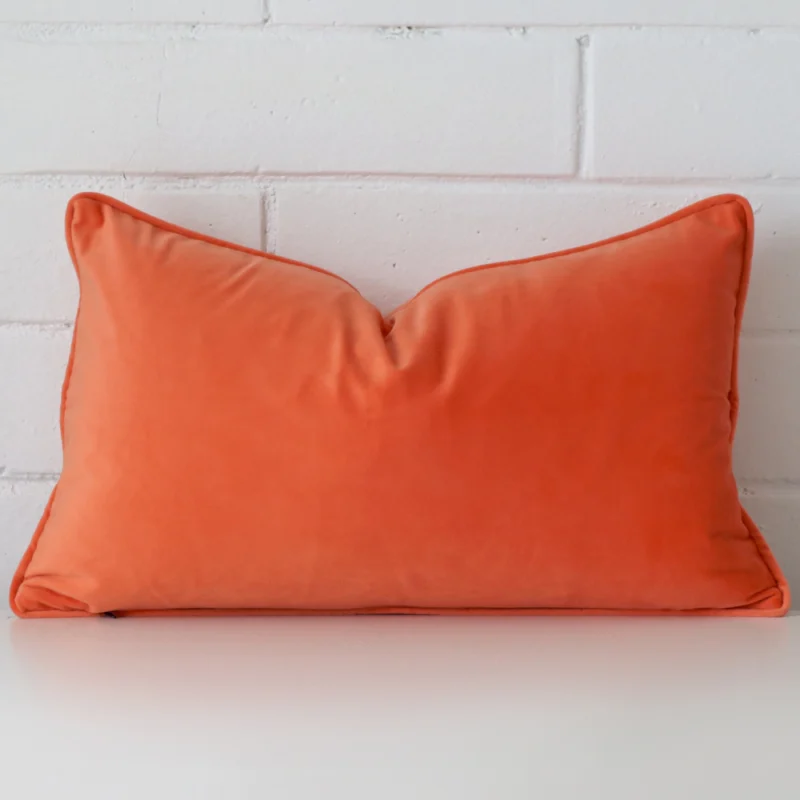 peach-velvet-rectangular-cushion-cover-30cm-x-50cm-sc779-30 A lovely rectangle orange cushion cover arranged in front of a white wall. It is made from a velvet material.