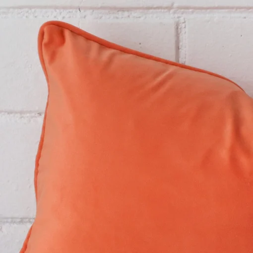 Enlarged shot of a rectangle orange cushion cover that highlights the velvet fabric.