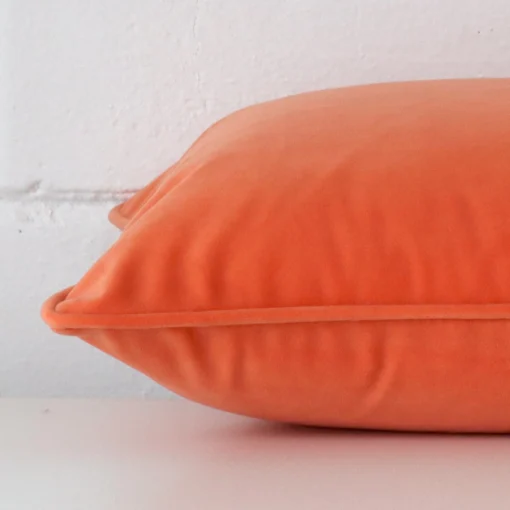 The seams of this velvet rectangle cushion cover in orange are shown.