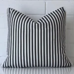 A square cushion in a delightful black and white tone rests against a white wall. The outdoor material appears to be of exceptional quality.