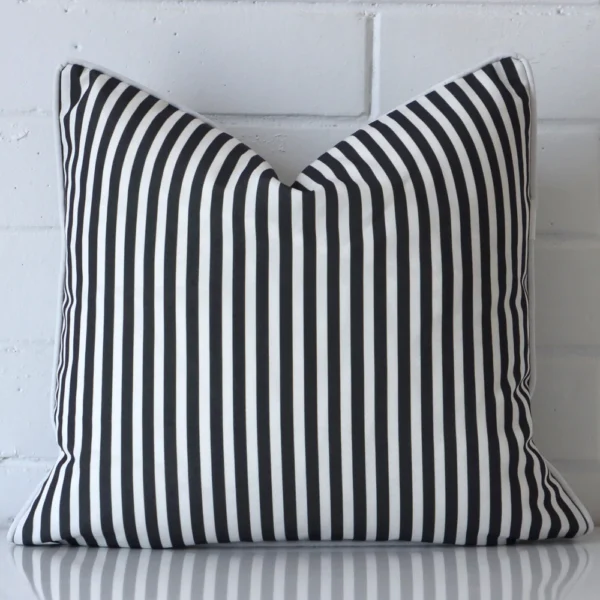 A square cushion in a delightful black and white tone rests against a white wall. The outdoor material appears to be of exceptional quality.