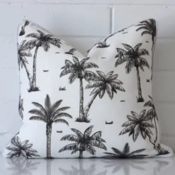 A brick wall that has a black and white cushion cover positioned in front of it. It has an exquisite outdoor material and a lovely square shape.