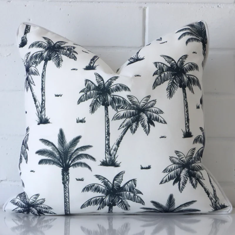 piha-palm-tree-waterproof-navy-blue-outdoor-cushion-cover-sc911-45 A pretty outdoor cushion cover is shown against a brick wall. It features a square shape and a navy blue colour design.