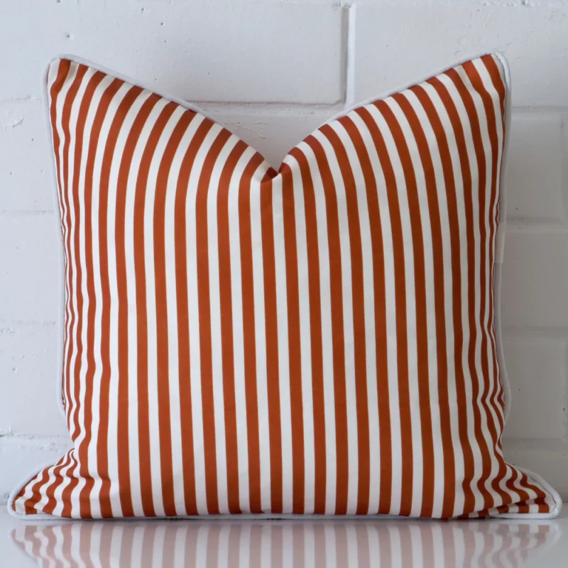 piha-terracotta-waterproof-striped-outdoor-cushion-cover-sc906-45 Terracotta cushion positioned in front of a brick wall. It has square dimensions and is made from an outdoor material.