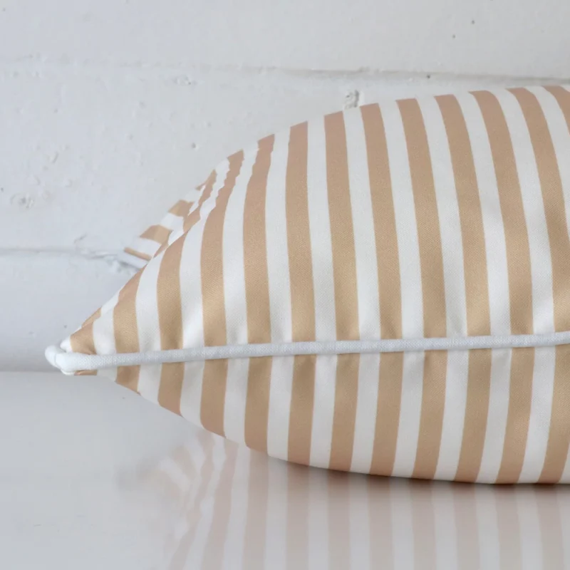Enlarged image of the side of this outdoor cushion. The angle highlights how the square design and striped decorative finish are joined along the seam.
