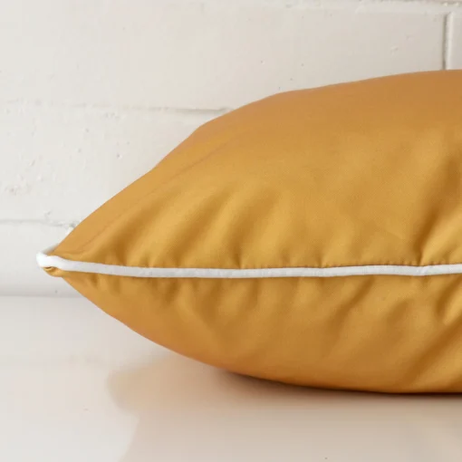 A side shot of an outdoor cushion cover. The angle shows the edge and the mustard tone with more clarity.