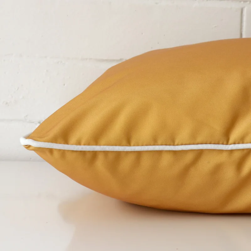 A side shot of an outdoor cushion cover. The angle shows the edge and the mustard tone with more clarity.