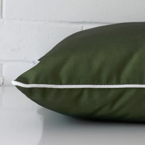 An outdoor olive green cushion cover shown laying on its side.