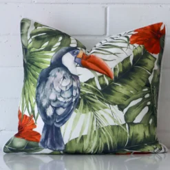 An alluring outdoor square cushion cover in front of a brick wall.