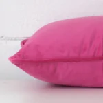 A rectangle velvet cushion positioned flat to show its seams. The pink colour is shown with more clarity.