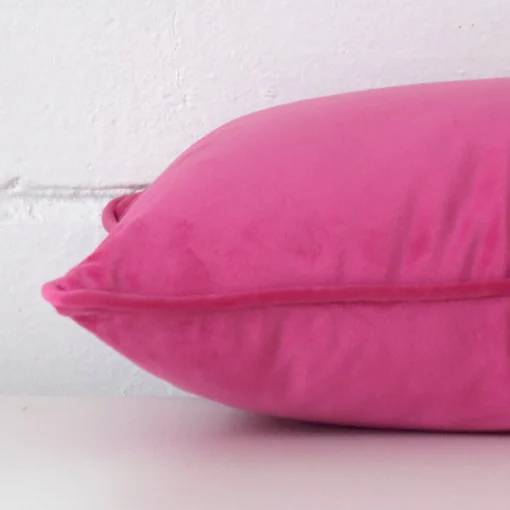 A rectangle velvet cushion positioned flat to show its seams. The pink colour is shown with more clarity.