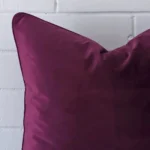 Horizontal edge view of front and back panels of a velvet cushion in a large size and with purple colouring.