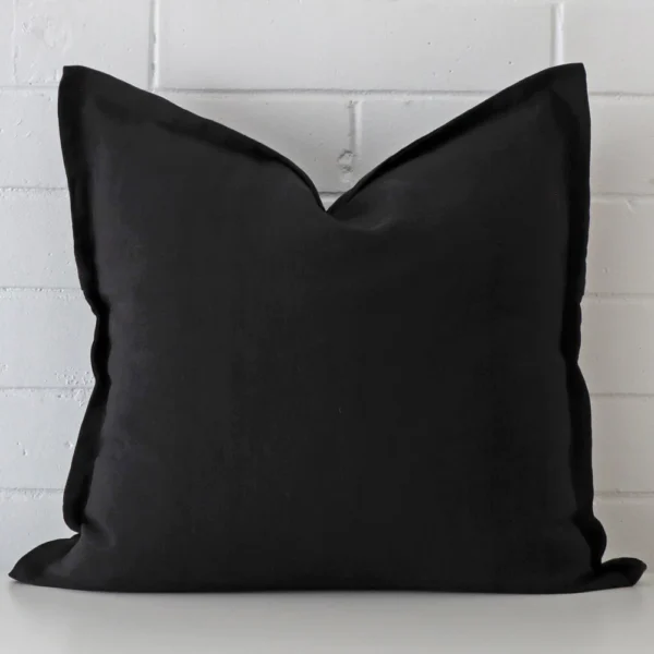 A hero shot of a large cushion cover. It is made from a deluxe linen fabric and features a black colour.