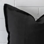 A black linen cushion cover’s corner is shown in more detail. It has a large size.