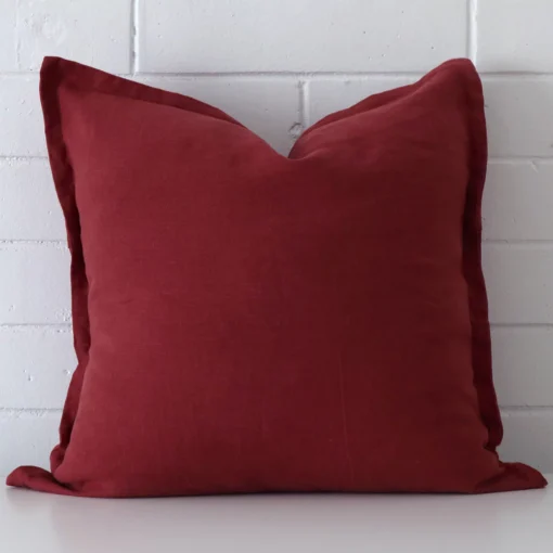 A bold linen cushion in a sleek large size with a rust tone of colour.