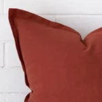 A magnified shot of a linen cushion cover in a large size and a terracotta colour.