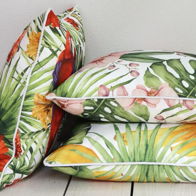 A rich and bright collection of tropical outdoor cushions lay in a neat pile.