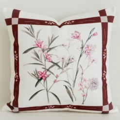 Burgundy bordered cushion cover with pink botanical centre print.