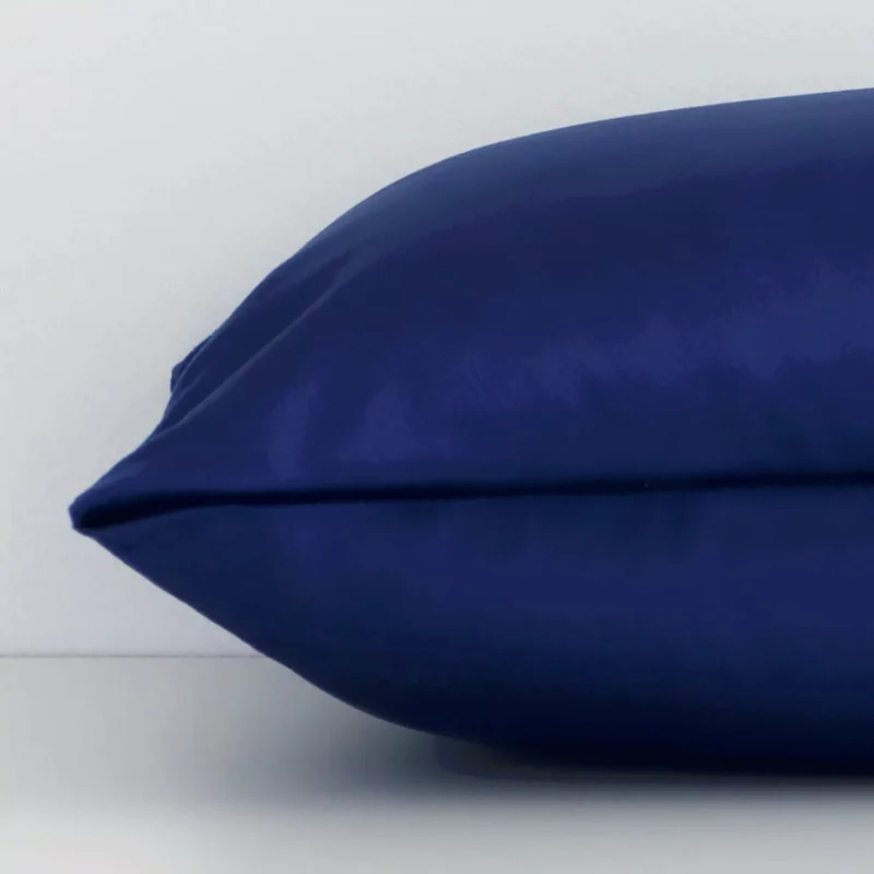 Rectangular solid-coloured cushion cover in royal blue colour sitting flat. The sideways viewpoint shows the seams of the velvet material.