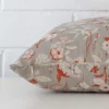 A terracotta cushion cover is laid flat. This angle shows the side of the linen fabric and its square shape.