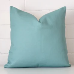 A bold linen cushion in a sleek square size with a teal tone of colour.