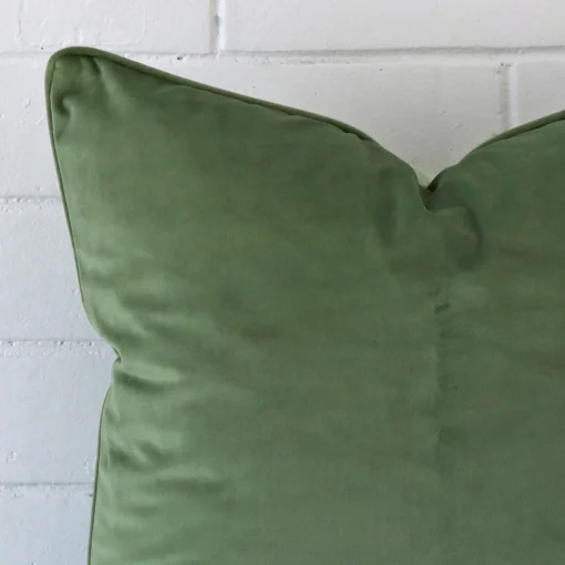 A sage velvet cushion cover’s corner is shown in more detail. It has a large size.