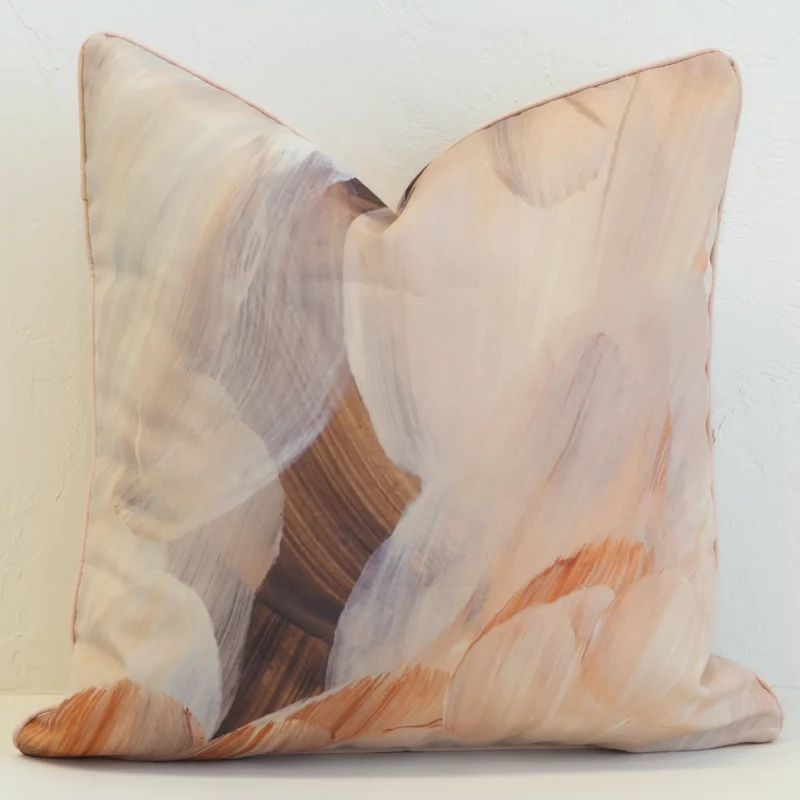 Striking brown outdoor cushion with abstract brush strokes in multiple earthy tones.