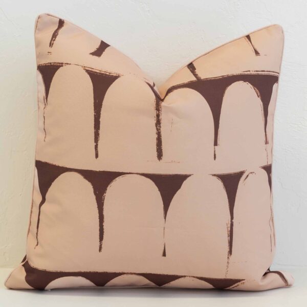 Sienna outdoor cushion with repeating arch pattern in warm brown on peach background.